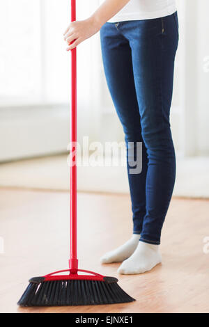 Close up della donna le gambe con la scopa piano di spazzamento Foto Stock