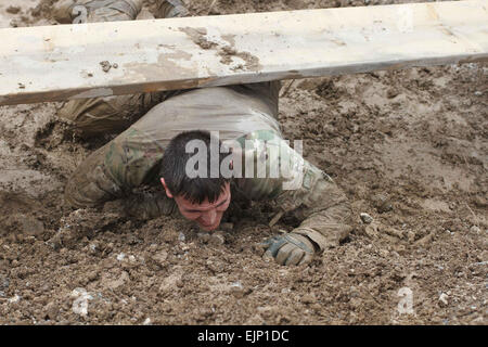 Un soldato gestisce l'over-e-sotto ostacolo pur partecipando in avanti nella posizione di base operativa Salerno, Afghanistan, fango Run, Marzo 24, 2013. Più di cinquanta soldati da varie unità dal portachiavi hanno partecipato al corso. Il due-miglio corso featured 15 diversi ostacoli che sfidano i soldati fisicamente e mentalmente, mentre aggiungendo gli elementi di acqua e fango per contribuire a rendere il corso ancora più difficile. Sgt. 1° classe Pinnington Abram, TF 3/101 Affari pubblici Foto Stock