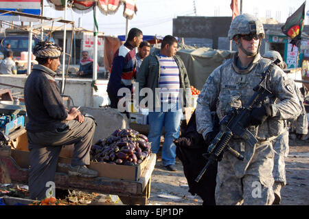 1Lt. Erik Wiesehan, di Canby, Ore., mantiene la sicurezza durante la briga. Gen. Robin Swanís visita ad un marketplace Husseniyah gen. 22. Wiesehan è essenziale il coordinatore dei servizi per il primo battaglione, 27 Reggimento di Fanteria "Wolfhound", 2° Stryker Brigade Combat Team "guerriero", XXV divisione di fanteria, attualmente fissata al 3° BCT, quarto Inf. Div., Divisione multinazionale - Bagdad. Swan è il vice comandante generale per la quarta divisione di fanteria e MND-B. Foto Stock