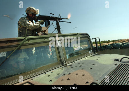 Stati Uniti Army Sgt. 1. Classe John Lavery, chimici, biologici, radiologici e nucleari sottufficiale con sede e Sede Società, 58a brigata di fanteria Team di combattimento, incendi sua M249 arma automatica della squadra nel corso di un esercizio pratico in difesa di base a Fort Dix, N.J., 28 maggio 2007. La 58th IBCT è a Fort Dix di treno in preparazione di un imminente la distribuzione in Iraq. Sgt. S. Patrick McCollum Foto Stock