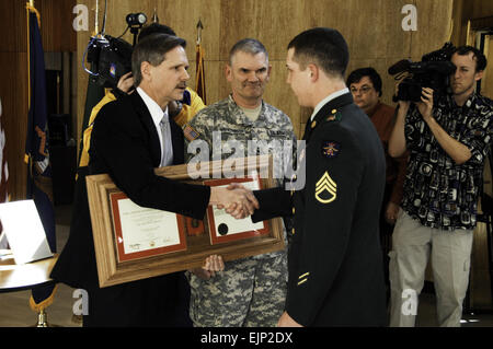 Governor John Hoeven scuote le mani con U.S. Il personale dell'esercito Sgt. Justin Lampert durante la presentazione di lui con il soldato medaglia del 14 marzo 2008, in Bismarck, N.D. Presentando inoltre la medaglia è stato il Mag. Gen. David Sprynczynatyk, centro di aiutante generale del North Dakota e Guardia Nazionale. Lampert ha ricevuto la medaglia per soggiogare un pistolero sparando a patroni in New York New York Hotel and Casino di Las Vegas, Nev. Chief Warrant Officer 3 Kiel Skager rilasciato Foto Stock