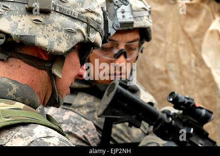 Spc. Michael Ingles primo piano, un nativo della città di Royce, Texas e SPC. Martin Aguilar, da Downey, California, cannone di entrambi i membri dell'equipaggio assegnati a batteria B, 1° Battaglione, 319Airborne campo reggimento di artiglieria, controllare un uomo della scheda di identificazione durante il funzionamento Bull scalpello Marzo 30. Foto Stock