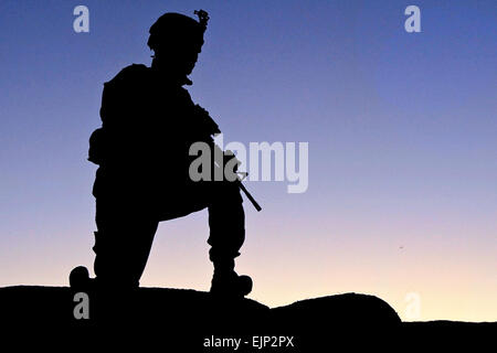 Un soldato dalla sede centrale e sede società, 1° Battaglione, 506th Reggimento di Fanteria, quarta brigata Team di combattimento, 101st Airborne Division si inginocchia in un eccesso di guardare la posizione sulla sommità di una parete qualot durante il funzionamento Steel Sky, un assalto dell'aria missione nei pressi del villaggio di Shakhmodkhel dic. 21. Spc. Lutero L. Boothe Jr., Task Force Currahee Public Affairs Office Foto Stock