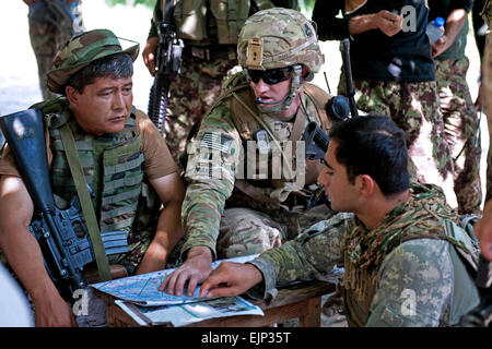 Stati Uniti Esercito Capt. Nicholas Drake, al centro dei colloqui con esercito afghano Lt. Col. Mohammad Bashir, sinistra, durante una pausa di pattuglia sulla periferia di Takiya Khana villaggio in Bati Kot distretto in Afghanistan la provincia di Nangarhar, 15 giugno 2013. Drake è Comandante della 101ª Divisione aviotrasportata forze di sicurezza consulenza e team di assistenza arcangelo, 1° Battaglione, 327Reggimento di Fanteria, 1° Brigata Team di combattimento. Sgt. Margaret Taylor Foto Stock