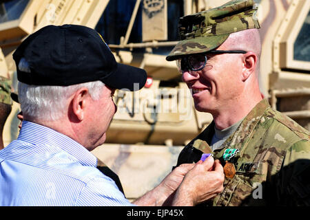 Il Segretario alla Difesa Robert M. Gates presenta il cuore viola e l'esercito encomio medaglia con valor di esercito Capt. Jeffrey Mackinnon, 1° Battaglione, campo 320reggimento di artiglieria, 2° Brigata Team di combattimento, 101st Airborne Division Air Assault a combattere avamposto Kowall in Afghanistan, 8 marzo 2011. Il Dipartimento della Difesa foto di Cherie Cullen Foto Stock