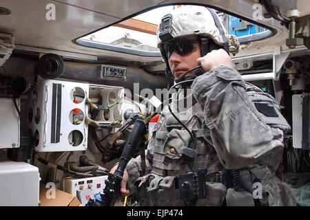 Stati Uniti Il personale dell'esercito Sgt. Bert Finlandia controlli il suo auricolare radio in un veicolo Stryker prima di pattugliamento in Taji, a nord di Baghdad, Iraq, 4 maggio 2009. La Finlandia è assegnato alla cinquantaseiesima Stryker Brigade Combat Team. Sgt. Doug ruoli Foto Stock