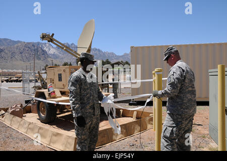 Soldati dell'ingegnere 86º Battaglione supporto impostare il satellite terminale trasportabile e congiunta del nodo di rete per l'esercizio il centro di controllo per essere utilizzati per l'integrazione con la rete Valutazione a White Sands Missile Range, NM. Nella foto è raffigurato il PFC. Danae Brinson, sinistra, Sgt. Shawna Riddle, in background e SPC. Clayton Kidwell. NIE 12.2 è il terzo di una serie di semi-valutazioni annuali, che è parte dell'Agile processo del ciclo di vita, progettato per integrarsi e matura dell'esercito rete tattici, condotta integrato e parallelo delle prove funzionali di selezionare programmi dell Esercito di registrare, valutare Foto Stock