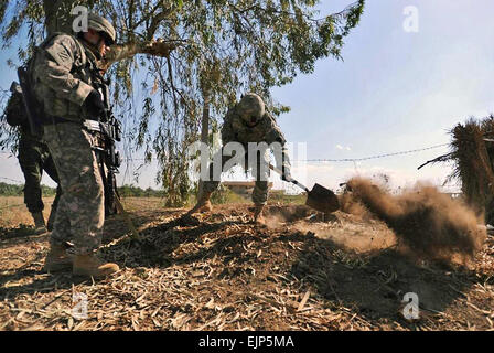 Un U.S. Soldato dell'esercito usa una pala per scavare e ispezionare il sospetto di una cache di armi durante una pattuglia di soldati dell'esercito iracheno vicino alla città di Sheik Hammad Village, Iraq, 10 aprile 2009. I soldati degli Stati Uniti sono assegnati per la ventottesima divisione di fanteria della società A, 1° Battaglione, 111Reggimento di Fanteria, 56th Stryker Brigade Combat Team. Sgt. Jacob H. Smith Foto Stock