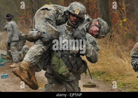 Stati Uniti Army Sgt. Andre Lobban, uno sperone candidato con Palehorse truppa, 4° Stormo, 2° reggimento di cavalleria porta un ferito attraverso un campo minato simulato durante uno sperone ride, Funzionamento Swift Saber, nov. 28, 2012, a caserma di Rose, Germania. Stati Uniti Army Spc. Joshua Edwards Foto Stock