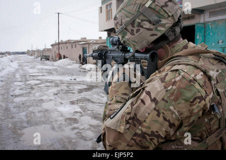 Stati Uniti Il personale dell'esercito Sgt. Tom Maahs, da acero ombra, N.J., chi è con la Task Force Paladin ordinanza sugli esplosivi gruppo di smaltimento, ispeziona il sito di un IED attraverso il suo fucile portata su una strada vicino il mercato del legno in Gardez, Feb. 18. IED è stata scoperta da parte degli enti locali afghani di polizia in uniforme e successivamente distrutto da un esercito nazionale afgano ordinanza sugli esplosivi gruppo di smaltimento. Foto Stock