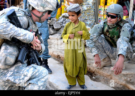 Un nazionale afghano di interprete e U.S. Esercito primo tenente Matteo Hilderbrand dal serbatoio bianco, 2° plotone, Delta Company, 1° Battaglione 4° Reggimento di Fanteria parla con un ragazzo afgano durante una pattuglia in un bazar nella provincia di Zabul dell'Afghanistan 29 giugno 2010. Il personale Sgt. William Tremblay Foto Stock