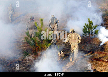 Stati Uniti I soldati dell esercito procedere oltre una sporcizia berm e sotto il coperchio dei fumi in un campo di addestramento durante un air-assalto, live-fire esercitare sulla Fort Bragg, N.C., 3 aprile 2009. I soldati sono assegnato all'ottantaduesima Airborne Division della società C, 2° Battaglione, 504th Parachute Reggimento di Fanteria, 1° Brigata Team di combattimento. Stati Uniti Esercito foto di Spc. Benjamin Watson Foto Stock