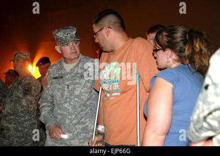 Prima Divisione dell esercito West Commander magg. Gen. Charles A. Anderson parla con PFC. James Armstrong e moglie Roxanne, durante una luce chimica veglia tenuto presso la North Fort Hood sito formazione Venerdì notte in ricordo di compagni e cari che furono uccisi e feriti nella sparatoria tragedia di Fort Hood in Texas, nov. 5. Armstrong altri tirato fuori pericolo nonostante sia girato due volte se stesso. Foto Stock