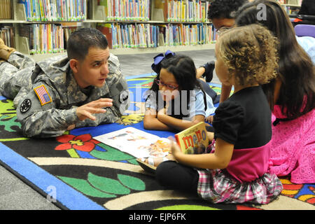 Esercito 2 Lt. Monserrate Vergara dal primo supporto missione comando, U.S. La riserva di esercito di Puerto Rico, legge un libro di ringraziamento a diversi bambini locali, pur partecipando in una storia ora evento tenutosi presso il Fort Buchanan biblioteca, nov. 20. Foto Stock