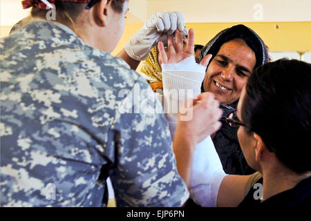 Stati Uniti Esercito il Mag. Lia Triolo, a sinistra, E DEGLI STATI UNITI Navy tenente j.g. Ayleigh Amaya assistere afgani in Afghanistan la provincia di Farah, 11 febbraio, 2012. Triolo è un chirurgo ortopedico con la 67th in avanti il team chirurgico Airborne e Amaya è un medico's assistant con Team di Ricostruzione Provinciale Farah. Stati Uniti Air Force foto Foto Stock