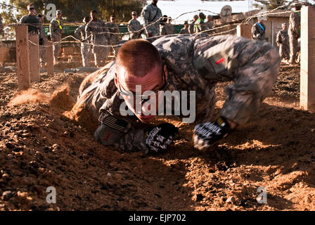 Sgt. Derek Czerniak, un soldato che serve su Camp Taji, Iraq, con il combattimento avanzato Brigata Aerea, 1a divisione di fanteria, esamina sotto un filo spinato ostacolo, nov. 7, durante la furia del demone, un concorso progettato per testare lo spettro completo di soldati' abilità di combattimento. Foto Stock