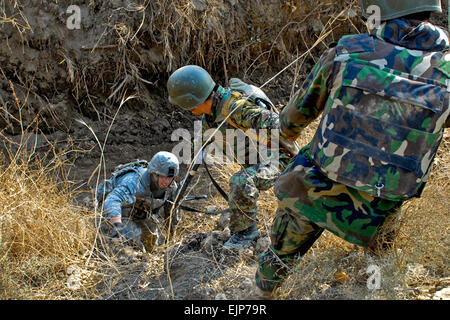 Esercito Nazionale Afghano soldati assistere 1Lt. Michael Viti, comandante di plotone, società A, 1° Battaglione, Ventiduesimo reggimento di fanteria al di fuori di un alveo Gen 9, durante la conduzione di pattuglia nei pressi del villaggio di Lowy Manarah nel quartiere Arghanda, provincia di Kandahar, Afghanistan. Stati Uniti Pfc dell'esercito. Nathan Thome Foto Stock