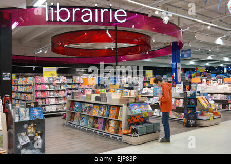 Belgio - Ottobre 2014: Boy è la lettura di un libro a fumetti presso la Librairie sezione in un Ipermercato Carrefour in Belgio Foto Stock