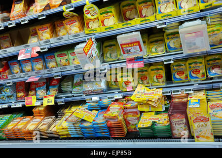 La Vallonia, Belgio - Ottobre 2014: ripiani refrigerati con una varietà di formaggio a fette dei pacchetti a un ipermercato Carrefour Foto Stock