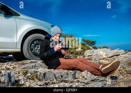 Fotografo con auto sulla cima della montagna Foto Stock