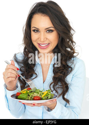 Attraente giovane donna di mangiare un insalata Foto Stock