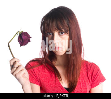 Close up triste donna azienda morto Fiore rosa Foto Stock