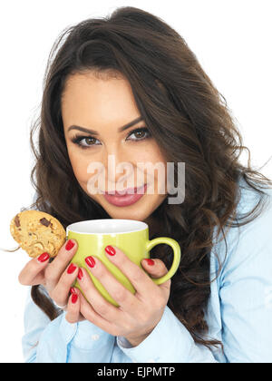 Felice positivo giovane donna godendo di tazza rinfrescante di fresco tè caldo o bevanda di caffè, isolato su bianco, da soli, con pezzetti di cioccolato biscotto Foto Stock