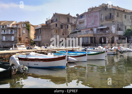 Piccole imbarcazioni e facciate di case sbiadito in una porta in Corsica Foto Stock