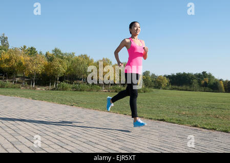 Giovane donna fare jogging nel parco Foto Stock