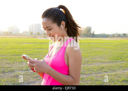 Giovane donna utilizzando smart phone in esercizio Foto Stock