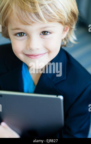 Sorridente ragazzo caucasico in business suit holding tavoletta digitale Foto Stock