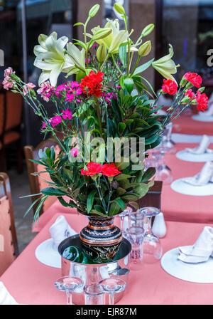 Impostazione tabella in un ristorante di un mazzo di fiori Foto Stock