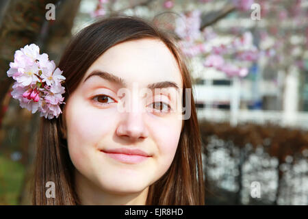 Donna felice con fiori di Cherry Blossom tree Foto Stock