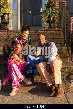 Americano africano sorridendo i genitori con bambini in costumi di Halloween Foto Stock