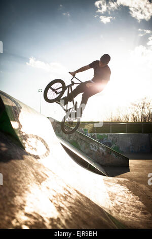 Uomo caucasico equitazione biciclette BMX a skate park Foto Stock