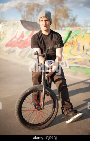 Uomo caucasico equitazione biciclette BMX a skate park Foto Stock