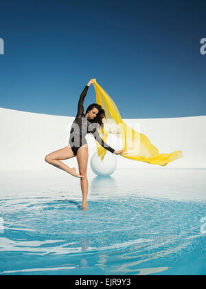 Caucasian woman dancing con tessuto sulla superficie dell'acqua Foto Stock