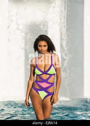 Razza mista donna che indossa colorato costume da bagno in piscina Foto Stock