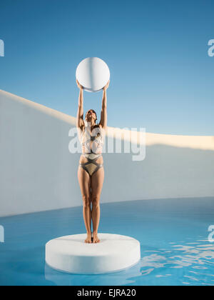 La donna caucasica sfera di tenuta su ghiaccio floe Foto Stock