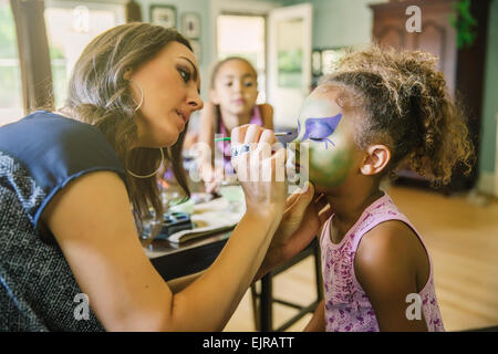 Madre volto dipinto di nostra figlia nel soggiorno Foto Stock