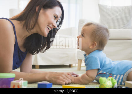 Razza mista madre giocando con il bambino sul pavimento Foto Stock