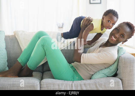 Nero madre e figlio giocando sul divano Foto Stock