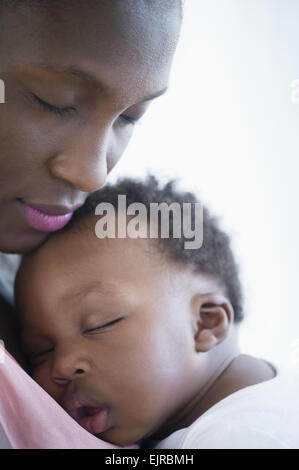 Close up della madre nera tenendo figlio che dorme Foto Stock