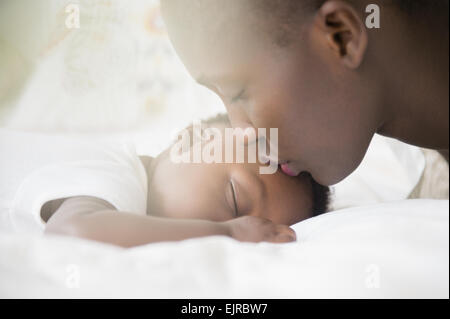 Close up della madre nera baciando la fronte del bambino Foto Stock