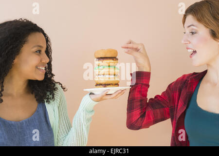 Le donne godono pila di ciambelle Foto Stock