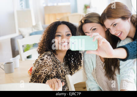 Le donne che prendono cellulare fotografia in sala da pranzo Foto Stock