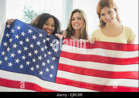 Donna sorridente holding bandiera americana Foto Stock