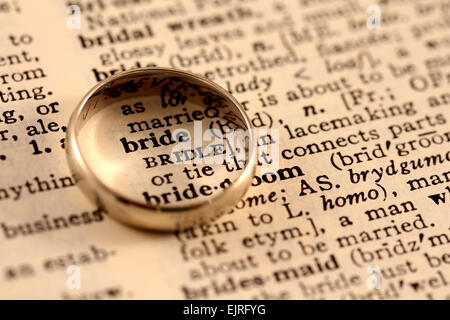 Una banda di nozze si siede in cima alla sposa di parola nel dizionario, volteggiare esso Foto Stock