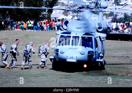 Soldati con il primo squadrone, 73rd reggimento di cavalleria, ottantaduesima Airborne Division, lo scarico di acqua e di cibo da un elicottero della Marina Militare, gen. 16, 2010. I soldati hanno istituito un forward base operativa presso l'ambasciata per aiutare a cominciare a stabilire la sicurezza e fornire aiuto umanitario. Articoli e risorse relative a Haiti e l esercito del coinvolgimento di /-news/2010/01/14/32919-haiti-terremoto-missione di soccorso/index.html Foto Stock