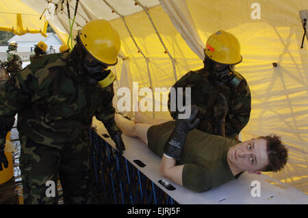 La simulazione di una vittima di un attacco chimico viene decontaminata da membri della sostanza chimica biologica risposta incidente vigore durante un livello nazionale Esercizio a Fort Lewis, nello Stato di Washington Il Marine Corps response unit, dal capo indiano, Md., è una sorta di risposta iniziale di forza. AF Tech.Sgt. Larry Simmons Foto Stock